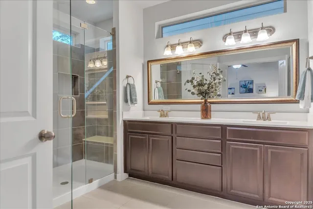 a bathroom with a sink and mirror with bathtub