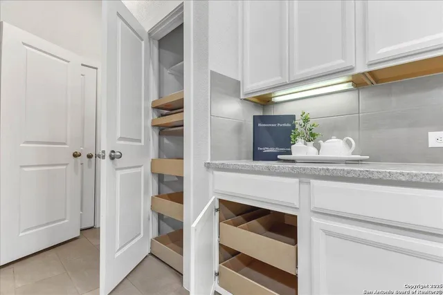 a kitchen with white cabinets and appliances