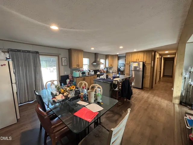 a kitchen with lots of wooden furniture appliances and cabinets