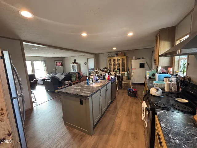 a view of a dining room with furniture a kitchen and chandelier