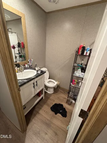 a view of a hallway with wooden floor and a living space