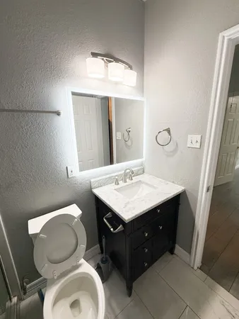 a bathroom with a sink toilet and mirror