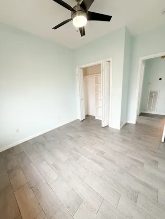 an empty room with a ceiling fan and window