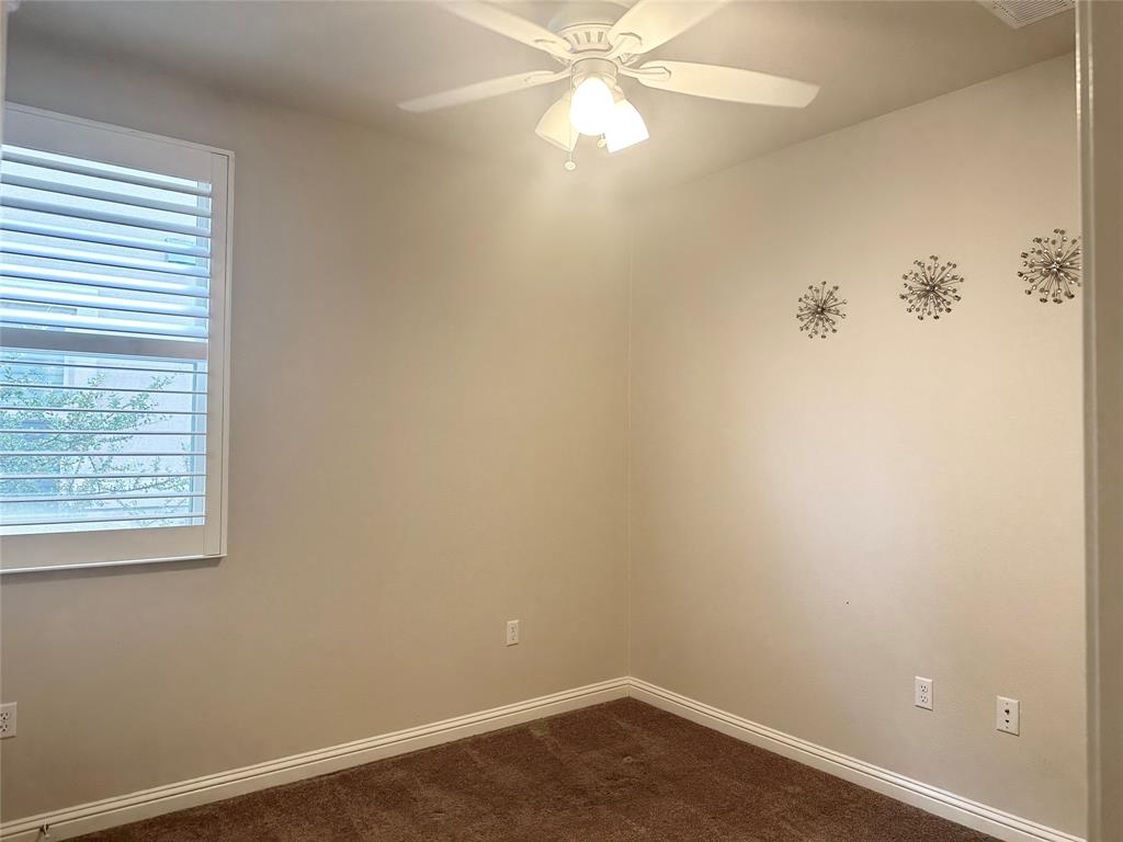6814 East Riverside Drive, Unit 26 Austin, TX 78741 - Photo 16 of 21 A well-lit bedroom features plush carpeting and a convenient ceiling fan for comfort.