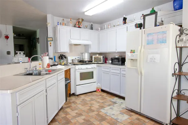 a kitchen with white cabinets and white appliances