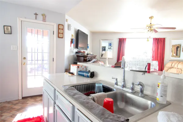 a kitchen with granite countertop a sink dishwasher and a stove with wooden floor