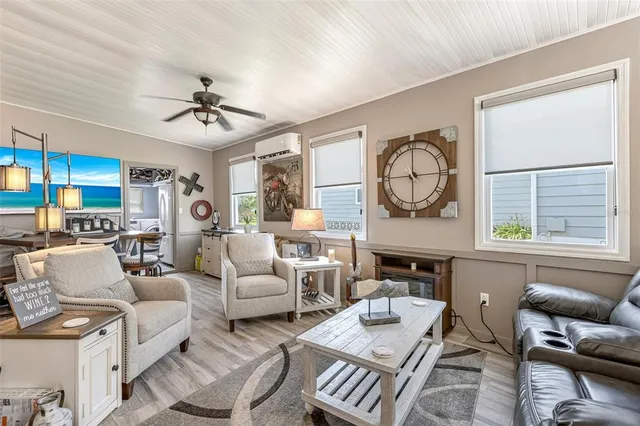 a living room with furniture ceiling fan and a large window