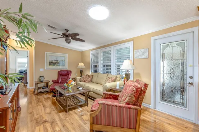 a kitchen with stainless steel appliances granite countertop a stove top oven a sink dishwasher a dining table and chairs with wooden floor