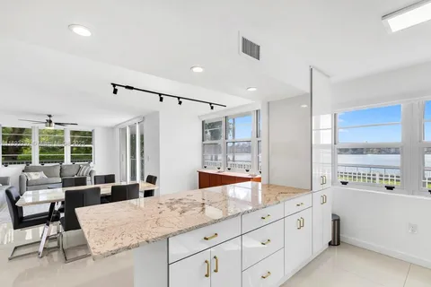 a spacious bathroom with a granite countertop sink and a large mirror