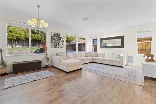 a living room with furniture and a chandelier