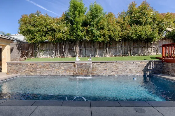 a backyard of a house with a garden and outdoor seating