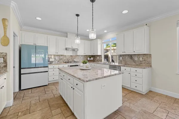 a kitchen with white cabinets appliances and a sink