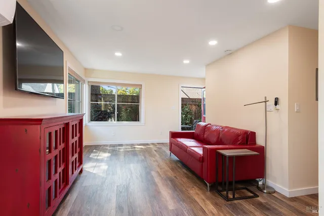 a living room with furniture a flat screen tv and a floor to ceiling window