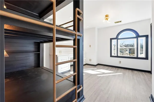 a view of an empty room with window and wooden floor