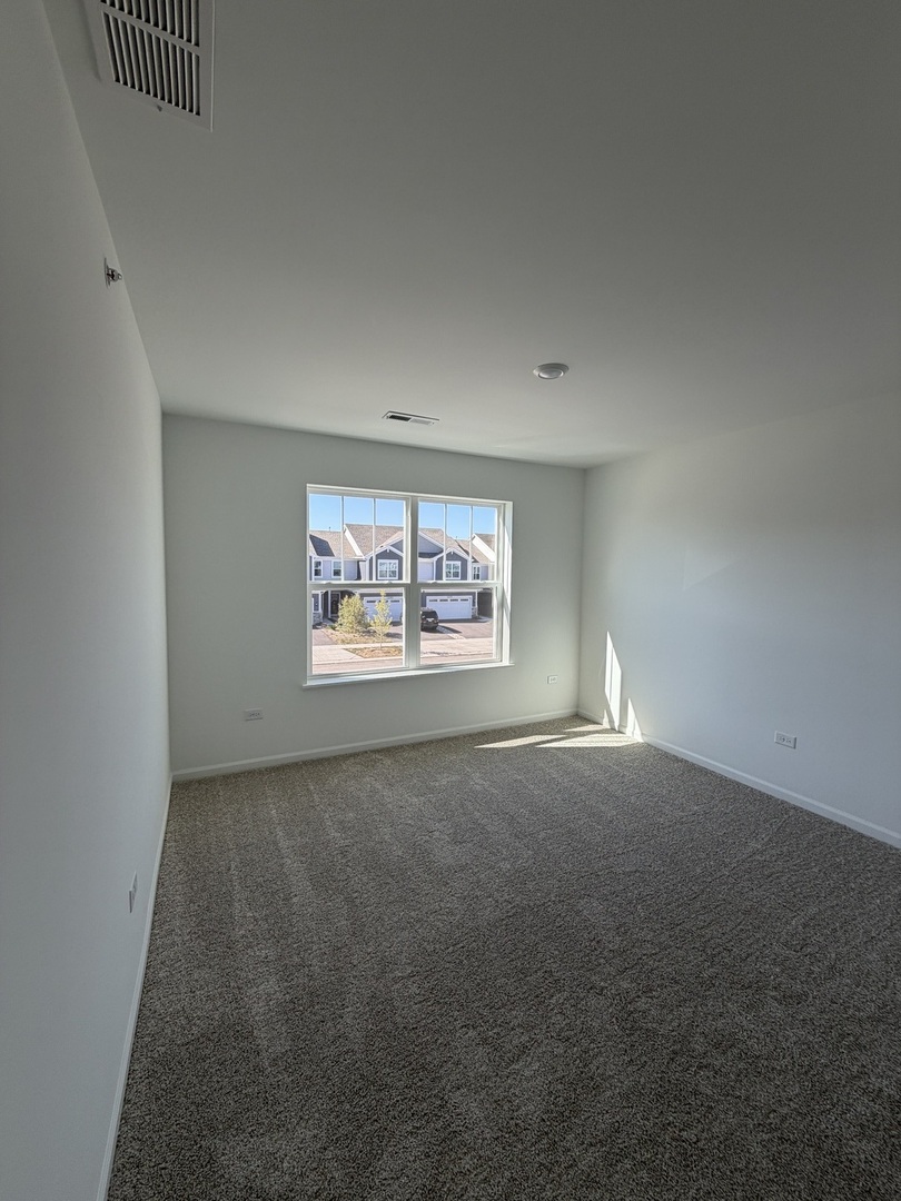 12058 Jordi Road Huntley, IL 60142 - Photo 9 of 13 an empty room with windows and fireplace