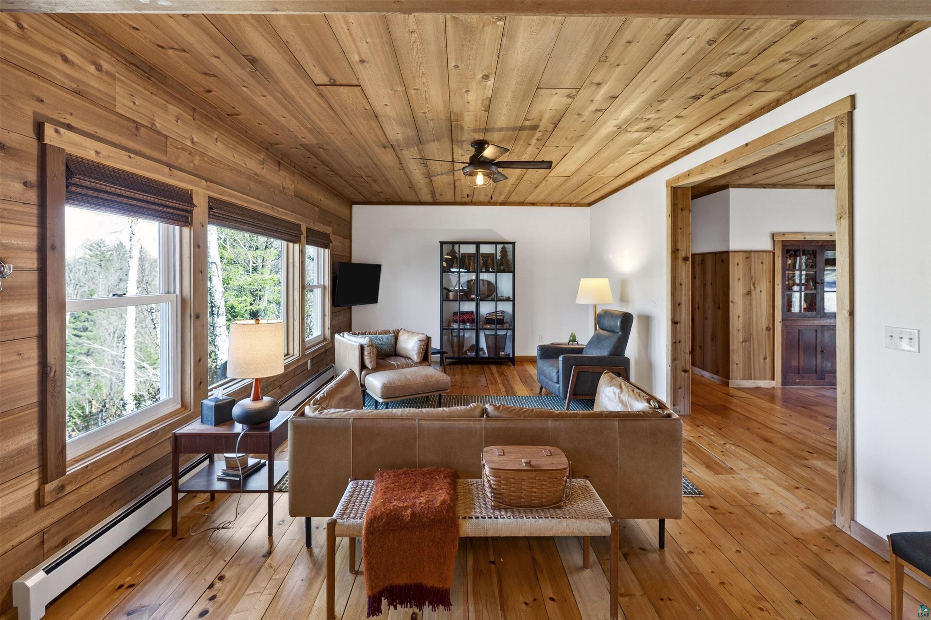 13885 Park Road Brule, WI 54820 - Photo 14 of 41 Living area featuring wood-finish wall paneling, a matching wood-finish ceiling, and wood-finish flooring