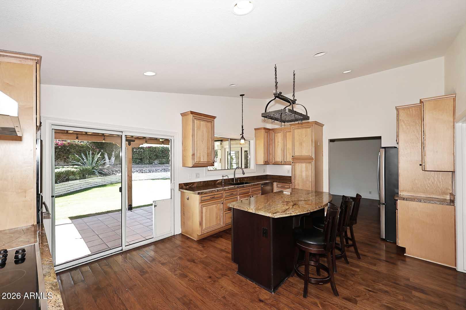 5426 South Lighthouse Lane Tempe, AZ 85283 - Photo 12 of 60 a kitchen with stainless steel appliances granite countertop a stove refrigerator and wooden floor