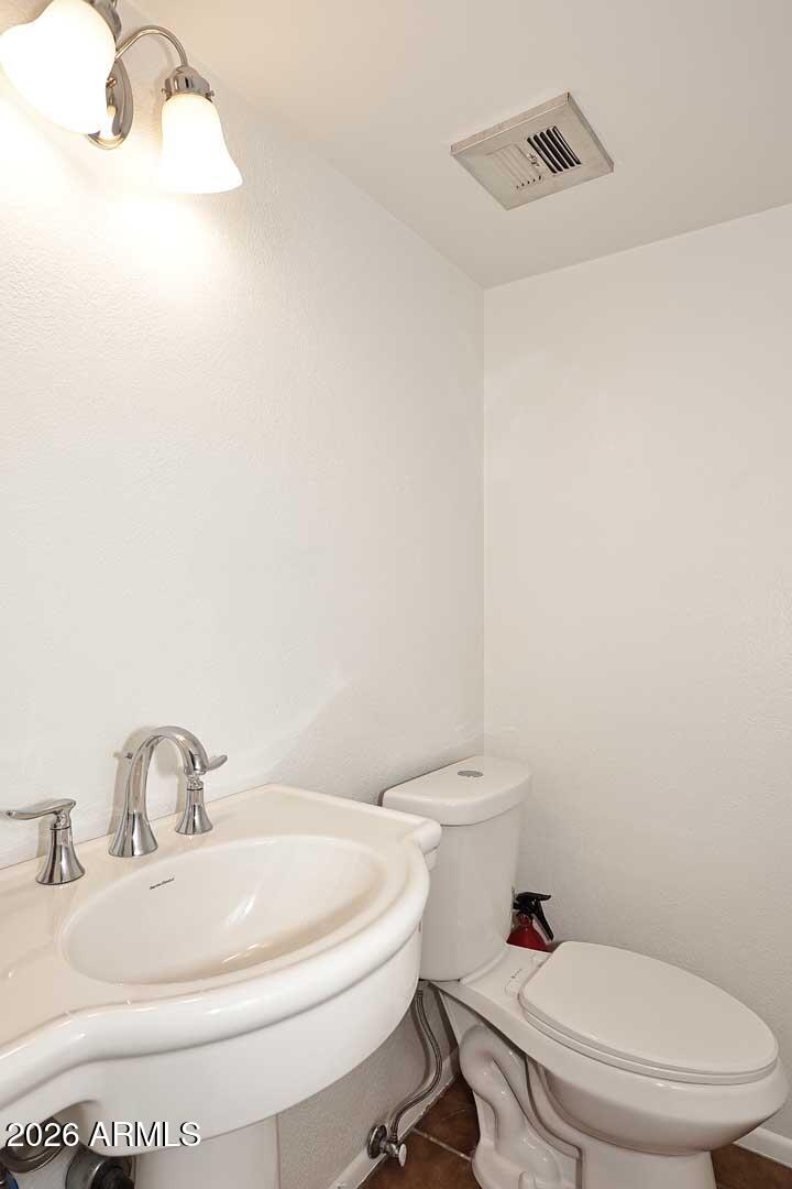 5426 South Lighthouse Lane Tempe, AZ 85283 - Photo 20 of 60 a white toilet sitting next to a bathroom sink