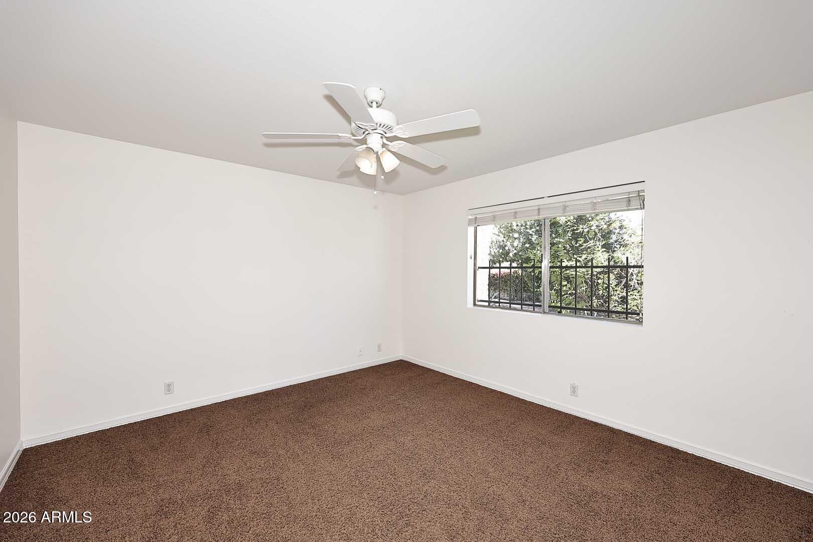 5426 South Lighthouse Lane Tempe, AZ 85283 - Photo 31 of 60 an empty room with a window and a fan