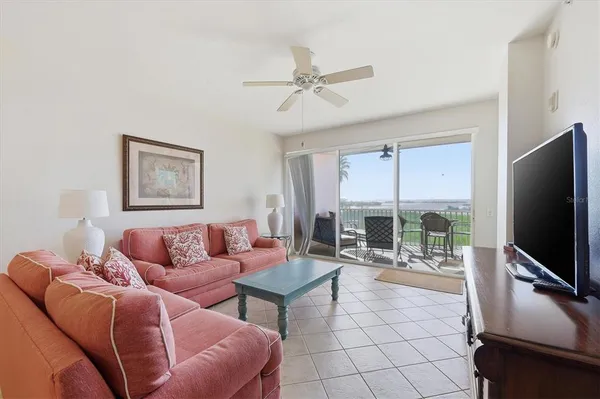 a living room with furniture a flat screen tv and a large window