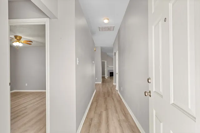 a view of a hallway with wooden floor and staircase