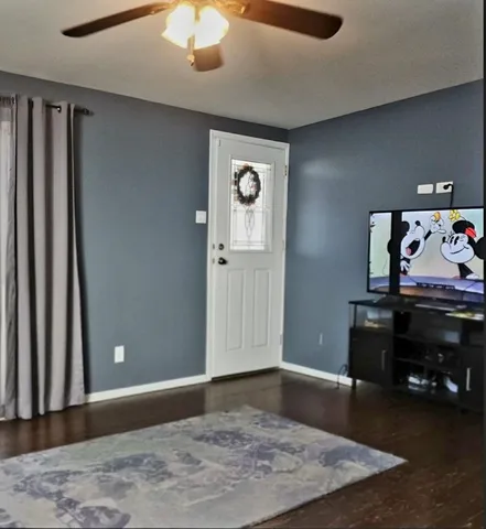 a view of a livingroom with a piano and wooden floor