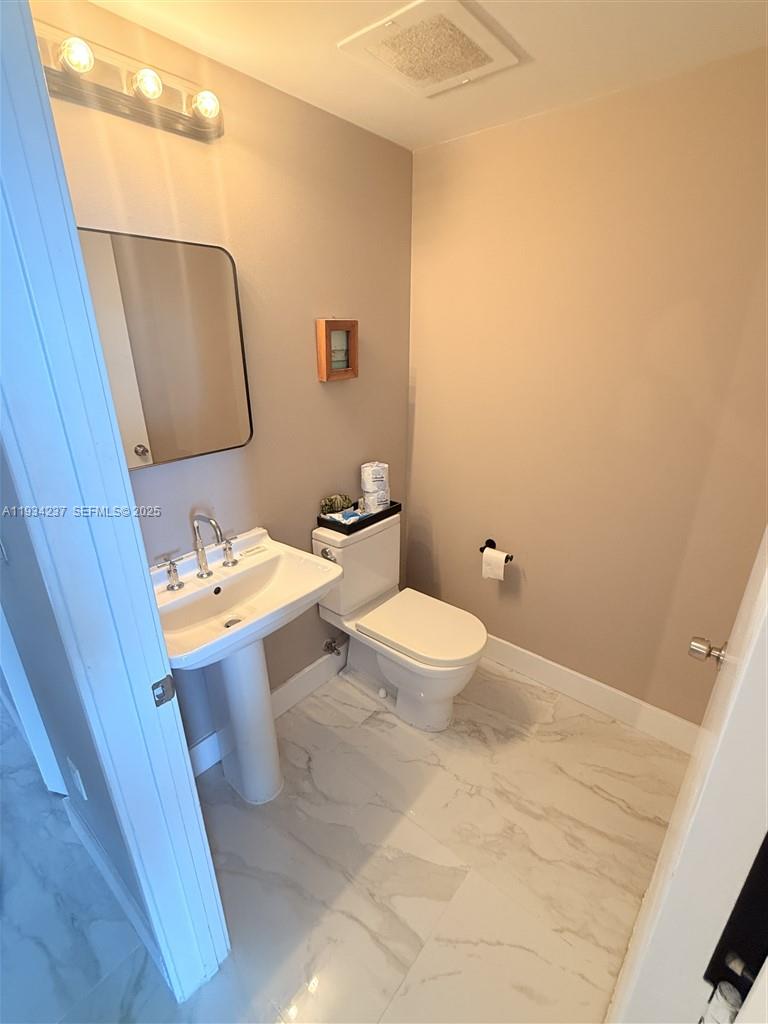 185 Southwest 7th Street, Unit 3109 Miami, FL 33130 - Photo 15 of 25 a bathroom with a sink mirror and toilet