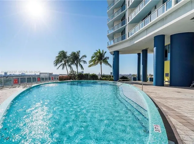 a view of swimming pool with outdoor seating and plants