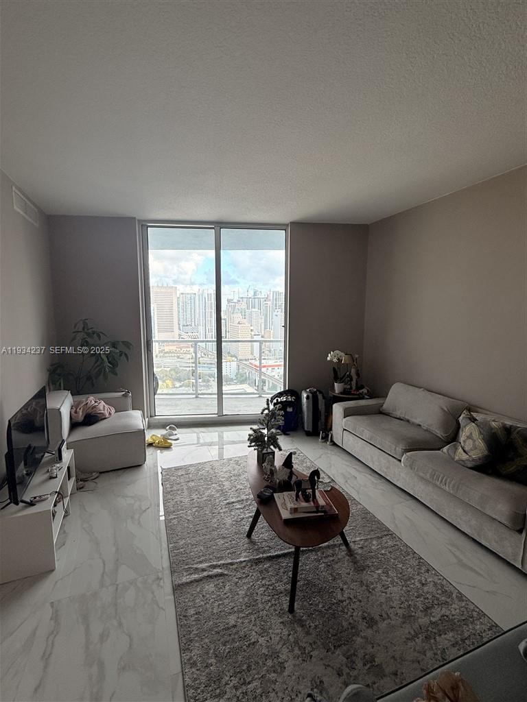 185 Southwest 7th Street, Unit 3109 Miami, FL 33130 - Photo 6 of 25 a living room with furniture and a large window