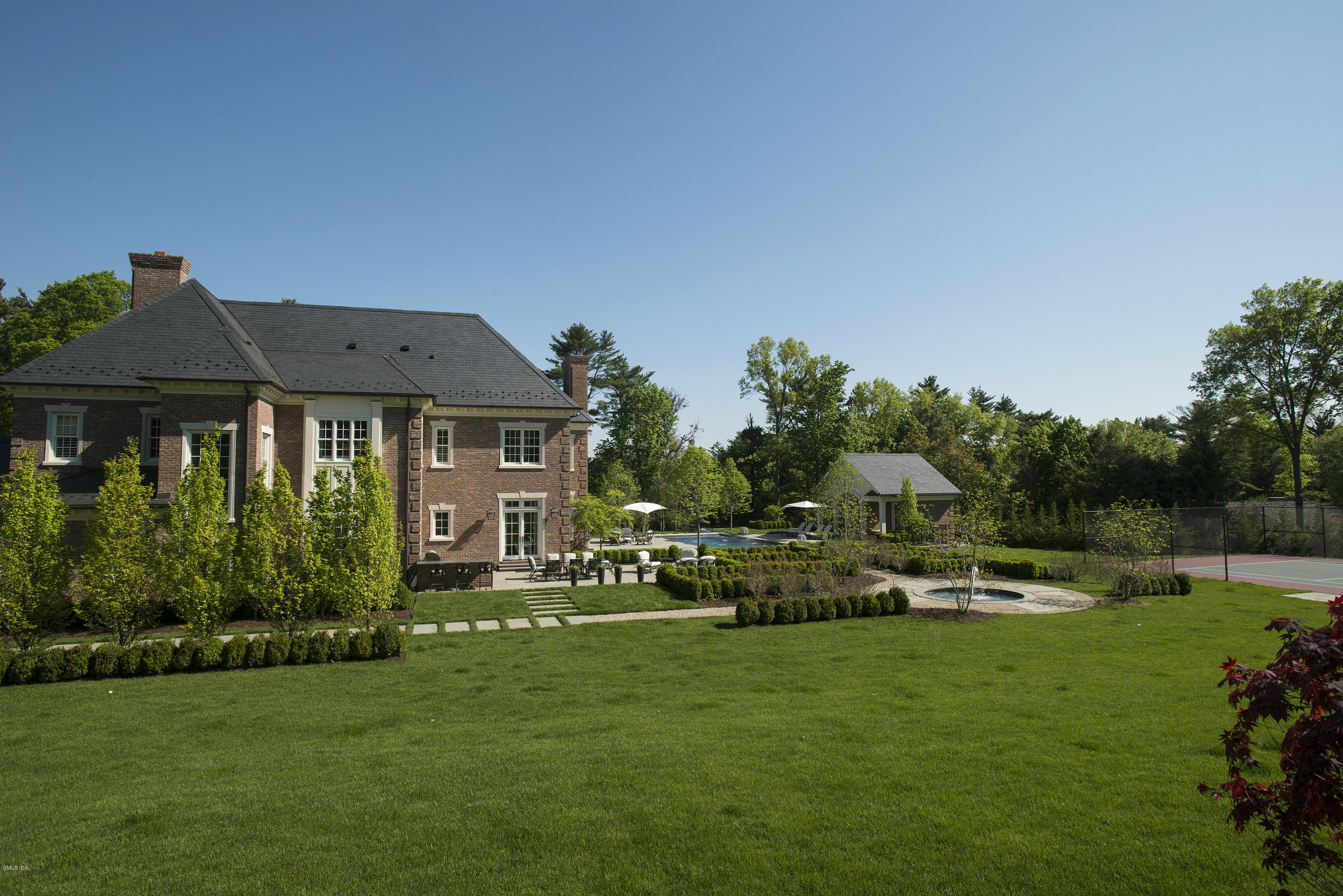 547 Lake Avenue Greenwich, CT 06830 - Photo 25 of 26 a front view of a house with a garden and trees
