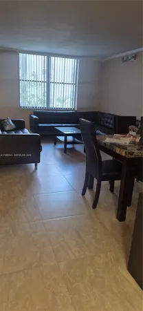 a living room with a table chair and a window