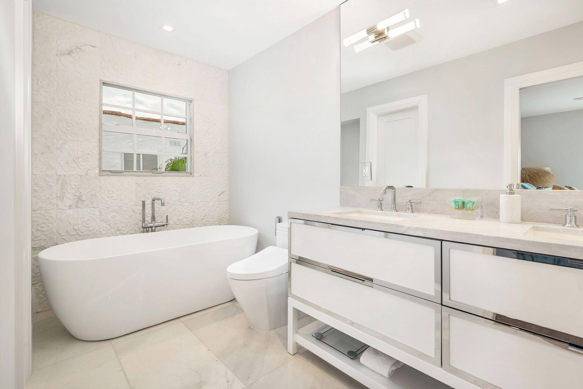 231 Argyle Road West Palm Beach, FL 33405 - Photo 15 of 41 a bathroom with a white tub a vanity a sink and a mirror