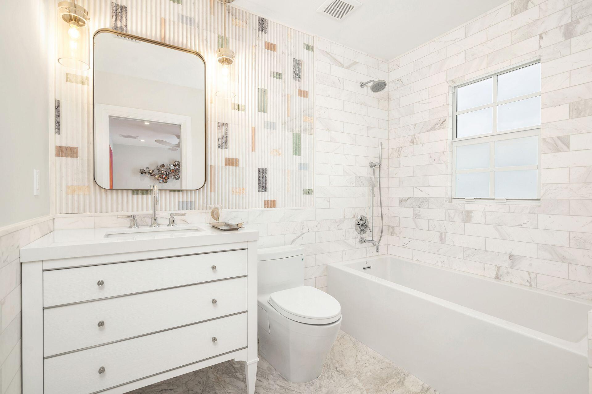 231 Argyle Road West Palm Beach, FL 33405 - Photo 24 of 41 a bathroom with a granite countertop toilet a sink a mirror a bathtub and shower