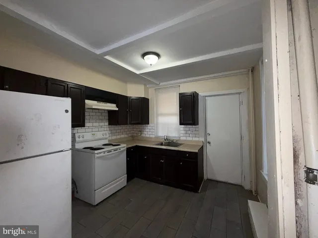 a large kitchen with stainless steel appliances granite countertop a sink and a refrigerator