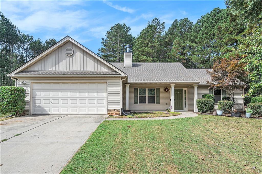 a front view of a house with yard and green space