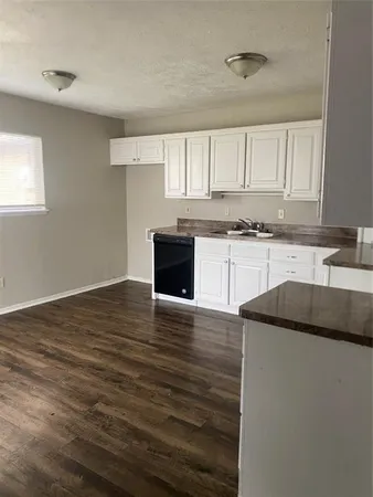 a kitchen with granite countertop a sink and a stove top oven
