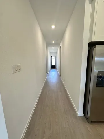 a view of a hallway with wooden floor