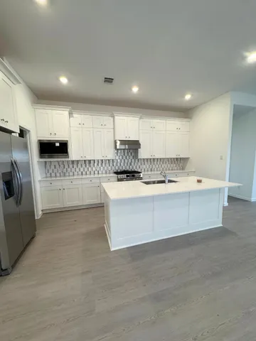 a large white kitchen with a large window