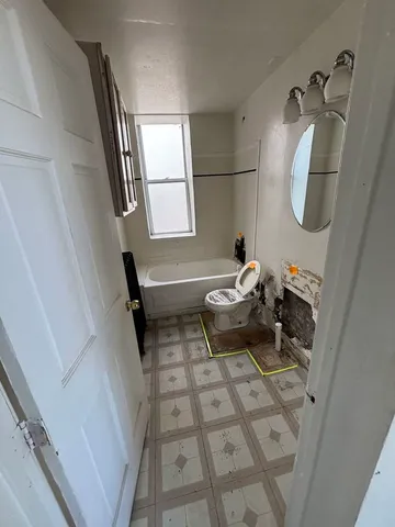 a bathroom with a sink toilet and mirror