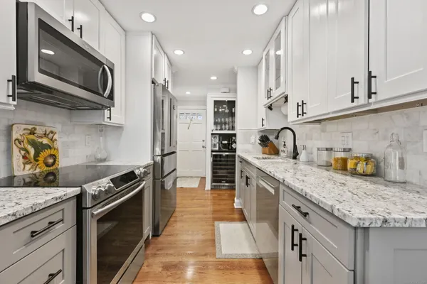 a kitchen with granite countertop a refrigerator and a sink