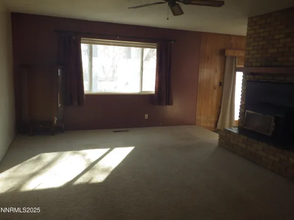 a view of an empty room with a fireplace and a window