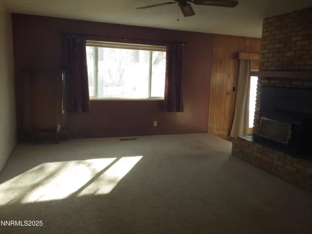 a view of an empty room with a fireplace and a window
