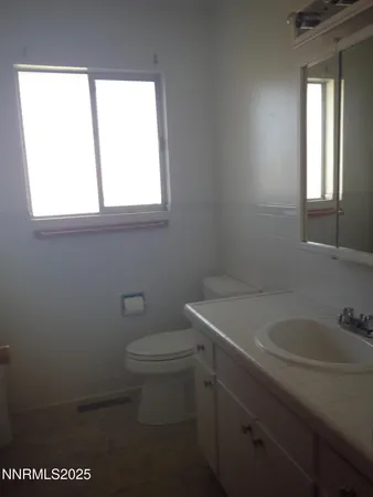 a bathroom with a toilet sink and window