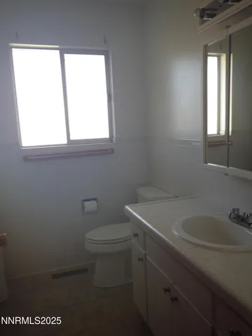 a bathroom with a toilet sink and window