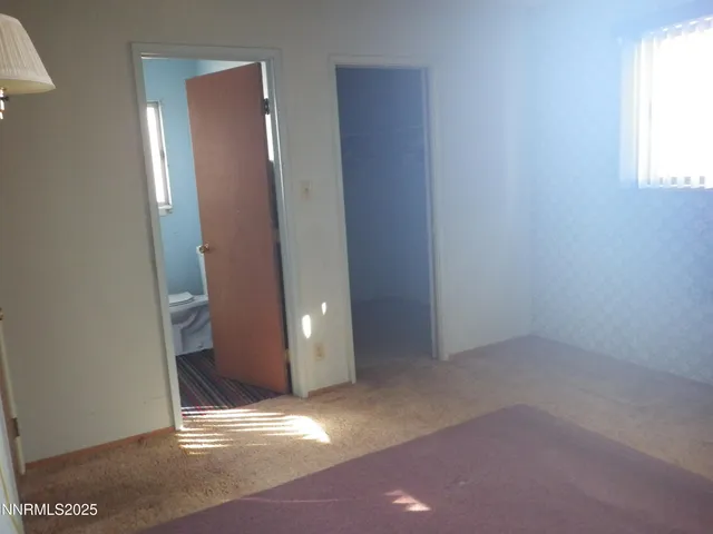 an empty room with windows and closet