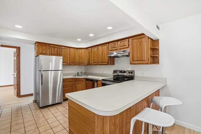 a kitchen with a sink a refrigerator and cabinets