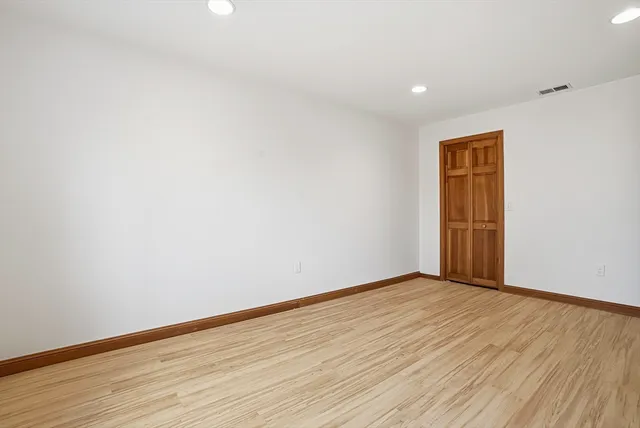 a view of an empty room with wooden floor