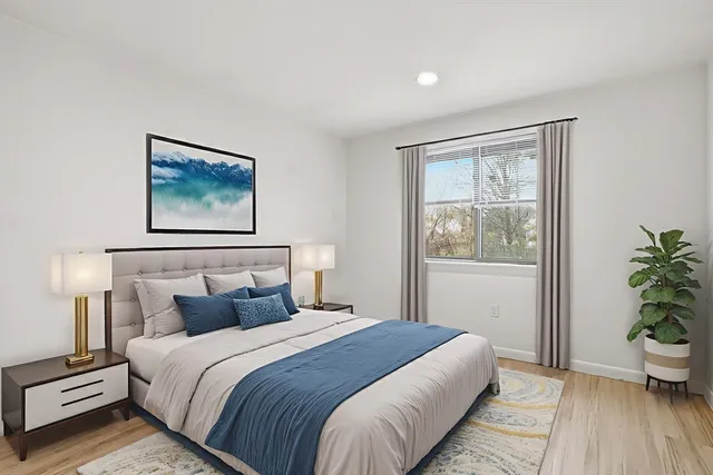 a bedroom with bed and wooden floor