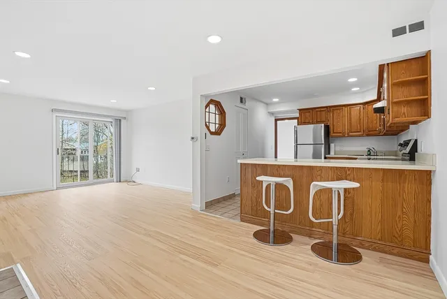 a kitchen with stainless steel appliances granite countertop a stove a sink dishwasher and a microwave with wooden floor