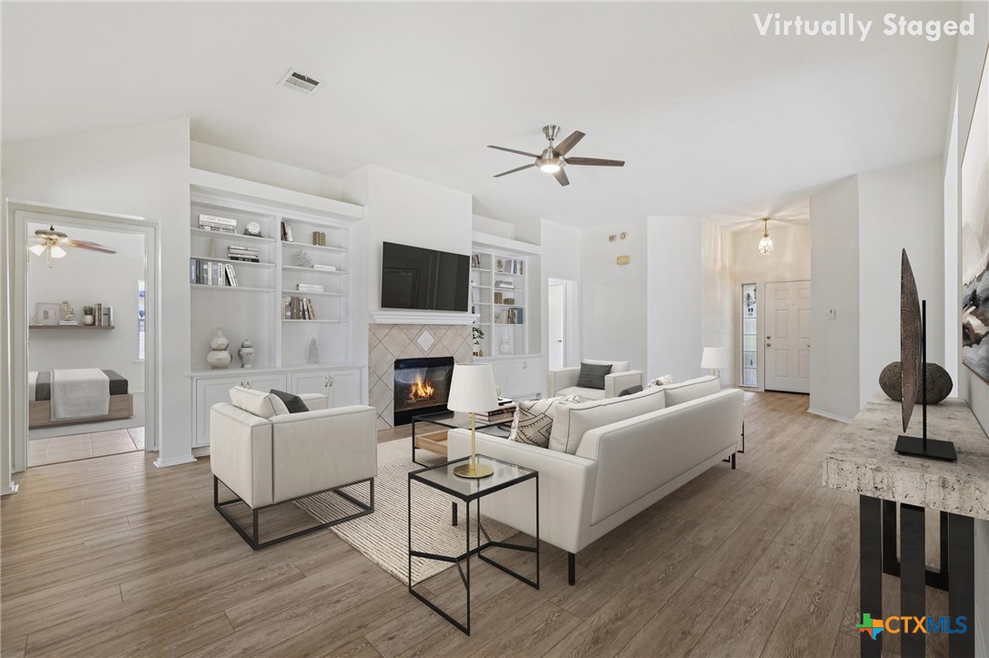 303 North Kings Canyon Drive Cedar Park, TX 78613 - Photo 2 of 24 a living room with furniture a fireplace and a flat screen tv
